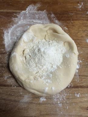 醒发好的面团做成一个碗状，里面放干面粉