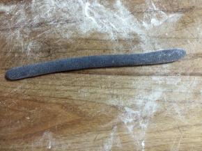 取一块黑面团揉成细长条