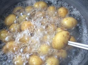 土豆煮至用筷子能轻易扎进去的程度，出锅晾凉后剥去土豆皮