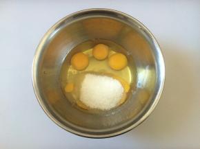 鸡蛋打在盆中，倒入白糖，手动搅拌均匀