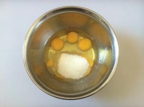 鸡蛋打在盆中，倒入白糖，手动搅拌均匀