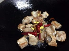 炒至微黄加入干辣椒、姜片、八角炒出香味，再加一勺米酒翻炒