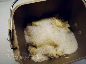 把绿豆沙倒进面包机中。同时倒进软化好的黄油、细砂糖和麦芽糖，开启面包机的翻炒功能，时间设置为45分钟。