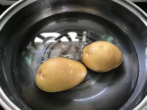 土豆放锅里蒸熟。
