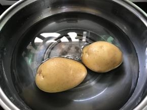 土豆放锅里蒸熟。