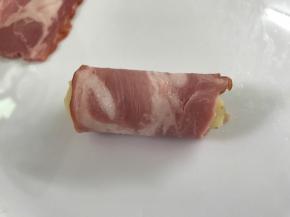 把培根片包着土豆泥卷起来。