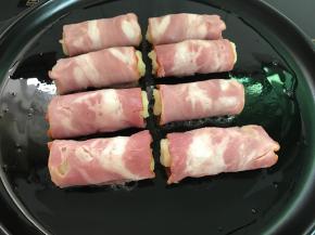 把培根卷接口朝下放入烤盘中。