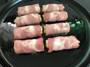 把培根卷接口朝下放入烤盘中。