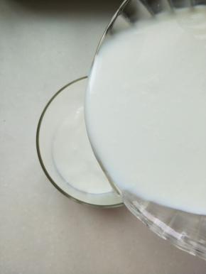 将牛奶倒入玻璃储蓄罐中