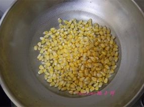 炒锅里再另倒入一碗水，倒入玉米粒，开火，煮至玉米粒变色；