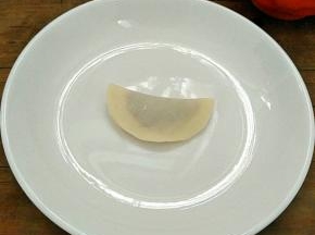 对折捏紧，成一个半圆。