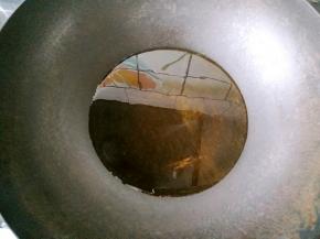 锅中加入比平时炒菜多一些的油，端起锅来转动，让锅的四周也沾上油。