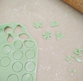 绿色面团擀成面片。压出圆形，再用剪刀剪成花形状。