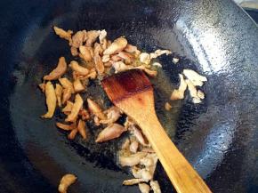 炒锅中放油，放入鸡腿肉翻炒，加入少许酱油和盐调味。