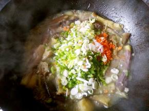 锅中汤汁渐少时把葱末麻椒末和胡萝卜末倒进锅中。