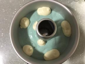 将蓝色蛋糕糊填满缝隙，并挤满模具一半，再挤入原色蛋糕糊。