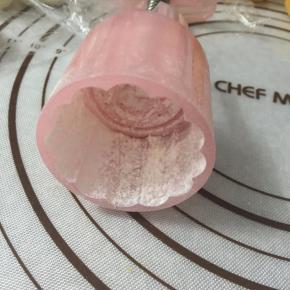 月饼模具中撒入少量熟粉，转一圈，让熟粉均匀的沾在月饼模上，再把月饼模在手心拍一拍，将多余的熟粉拍出。