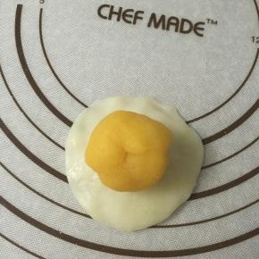 取一面团把馅料包入，像包包子一样捏紧。