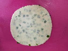 用擀面杖将饼皮擀大擀圆。