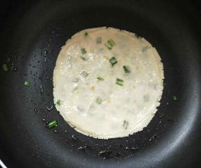 平底锅内放少许油，中火开始烙葱油饼。