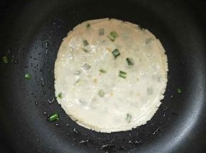 平底锅内放少许油，中火开始烙葱油饼。