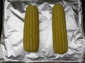 甜玉米去皮洗净，沥干水份，烤盘里垫上锡纸，玉米放在烤盘上