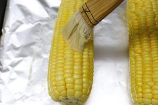 蒸好的玉米拿出来，在玉米表面刷上一层黄油