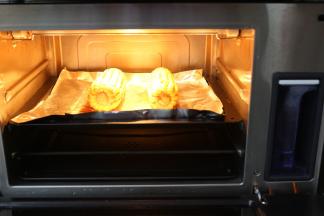 西屋蒸汽烤箱先预热上下火210度10分钟，再把玉米放入烤箱中层210度20分钟，中途要拿出来翻面再刷上一层蜜汁烤肉酱再撒上孜然粉继续再烤