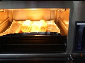 西屋蒸汽烤箱先预热上下火210度10分钟，再把玉米放入烤箱中层210度20分钟，中途要拿出来翻面再刷上一层蜜汁烤肉酱再撒上孜然粉继续再烤
