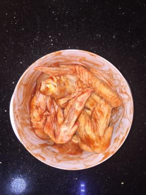 稍微给鸡翅按摩几分钟让调料更好吸收，盖上保鲜膜盖放入冰箱腌制3小时