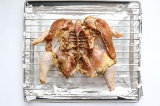 烤盘垫上锡纸，烤网上放处理好的鸡，是趴在烤网上的，鸡的正面向下，鸡的里面向上，烤网放在烤盘上，这样烤鸡滴下的油，烤盘接着