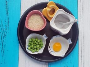 准备食材：大米70克、豌豆20克、蛋黄1个、食盐少许。