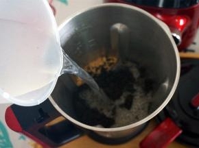 将全部芝麻粉、花生粉，100毫升纯牛奶，900毫升清水放入破壁机的全钢热饮专用杯。