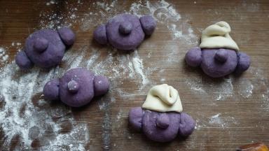 紫色部分全做好后，取一块白色，白色约重20g。用擀面杖擀开（形状不讲究）沾点水包在蓝精灵头点上，再折回来。就完成帽子啦。