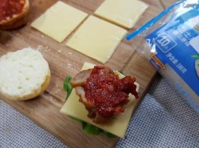 在鸡腿肉上再涂抹番茄酱，盖上另一片汉堡胚用牙签固定好，我完成了。