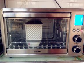 将吐司盒放进烤箱，底下放一碗热水，选择东菱烤箱的02发酵档，发酵50分钟