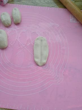 擀成长舌状，再用擀面杖朝中间压出一条痕。