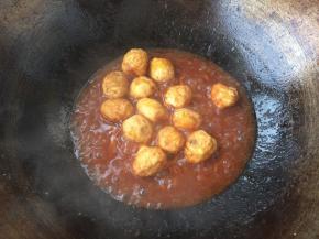 放入炸好的鹌鹑蛋，翻炒至每一颗都裹上酱汁