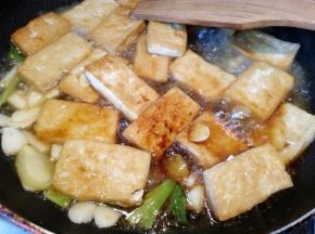 倒入半碗高汤，大火烧开，加入一小勺盐，小火焖煮5分钟让豆腐入味。