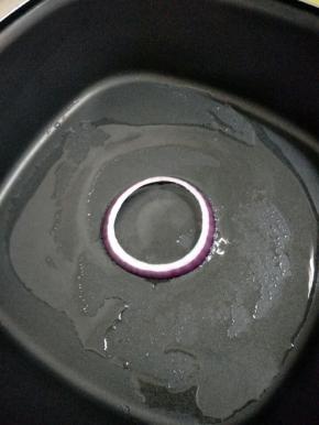 把洋葱圈放入抹油的锅中。