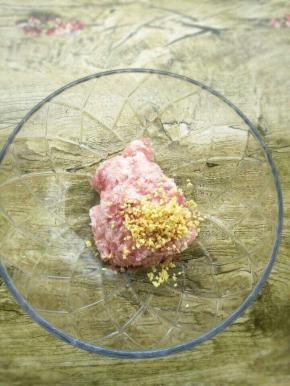 把猪肉、姜未放入碗中，加入料酒和盐拌匀。