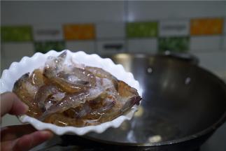 锅里加姜爆香，将明虾下锅煎炒至外壳微酥脆。