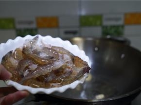 锅里加姜爆香，将明虾下锅煎炒至外壳微酥脆。