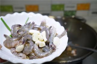 再将蒜粒明虾下锅煎炒至出味。