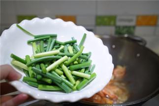 再将蒜苔下锅同炒至出香。