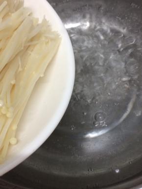 汤锅里加入适量的水烧开，再将金针菇放入焯水