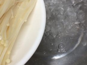 汤锅里加入适量的水烧开，再将金针菇放入焯水