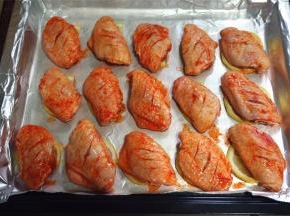 将腌制好的鸡翅摆放到柠檬片上。