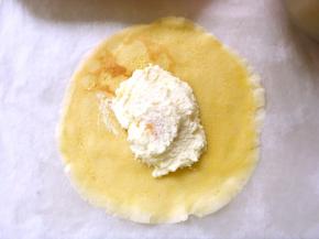 冰箱取出凉透的面饼，取一张面饼光滑面朝下，抹一点淡奶油，加入芒果，上面再盖上一点淡奶油