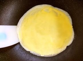 面糊加热后，中间会鼓起来，证明面糊已经煎好，用刮棒将边缘翘起，装盘摊第二张